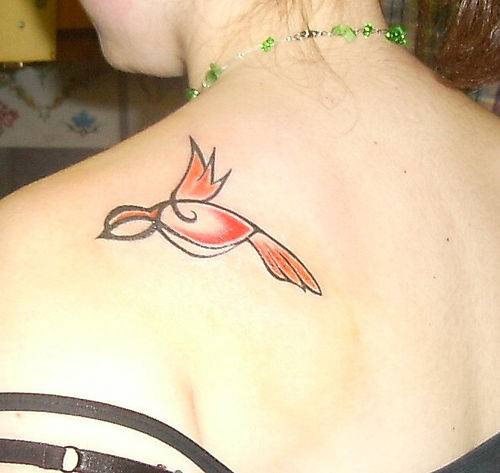 Tatuaggio delicato sulla spalla l&quotuccellino colorato