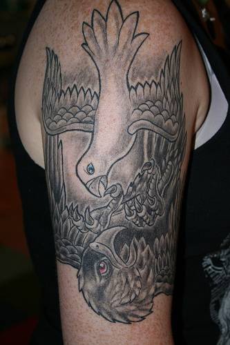 Tatuaje en el brazo, paloma lucha con águila