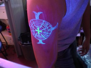 Glowing cross uv ink tattoo