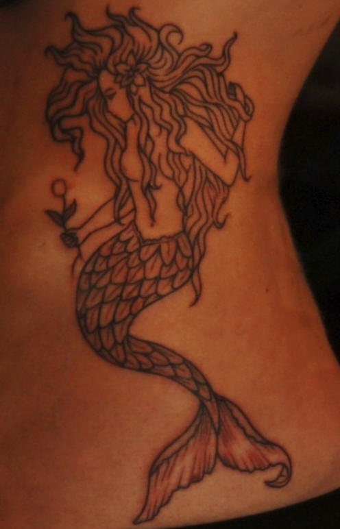 Black mermaid holding flower tattoo