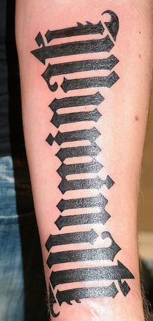 testo caligrafico tatuaggio nero sul braccio