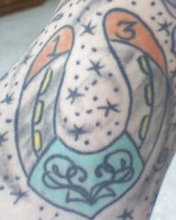 Tatuaje de una herradura con la cifra13 y varias estrellas