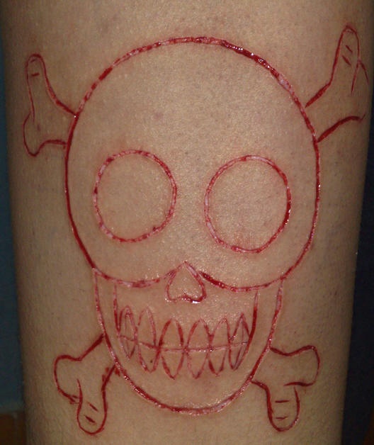 Tatuaje sacrificio en la piel calavera con huesos