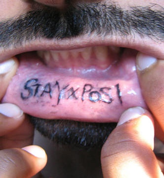 Bottom lip tattoo, stay x posl, black styled inscription