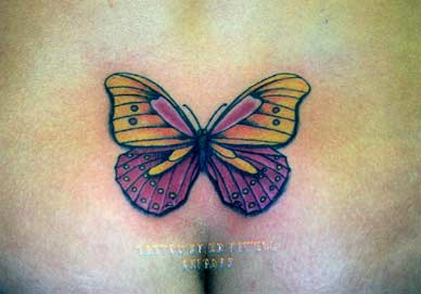 Tattoo mit lila und gelbem Schmetterling am unteren Rücken