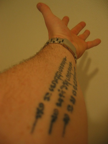 indu" buddista mantra testo sul braccio tatuaggio