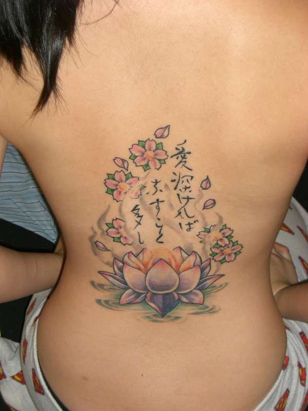Le tatouage de lotus avec des inscription bouddhiste sur le dos