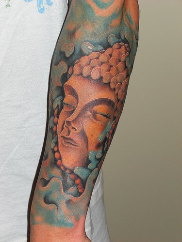 Stone buddha face coloured sleeve tattoo