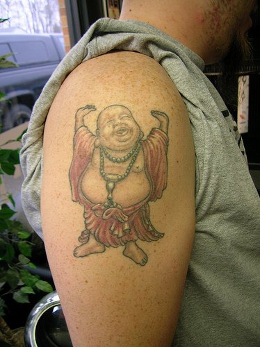 Laughing buddha in red tattoo