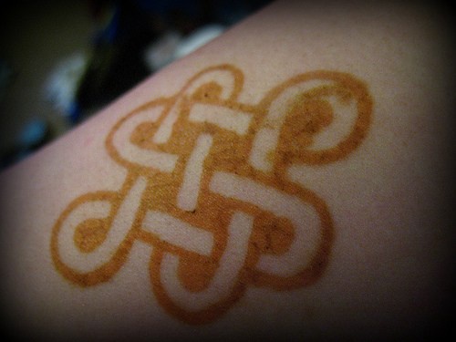 Le tatouage de symbole bouddhiste doré