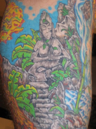 Stone buddha statue in forest coloured tattoo