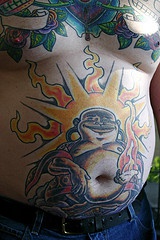Glad buddha belly with sun behind tattoo