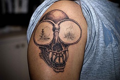 Skull with bug eyes tattoo on shoulder