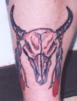 Bull skull with feathers on horns tattoo