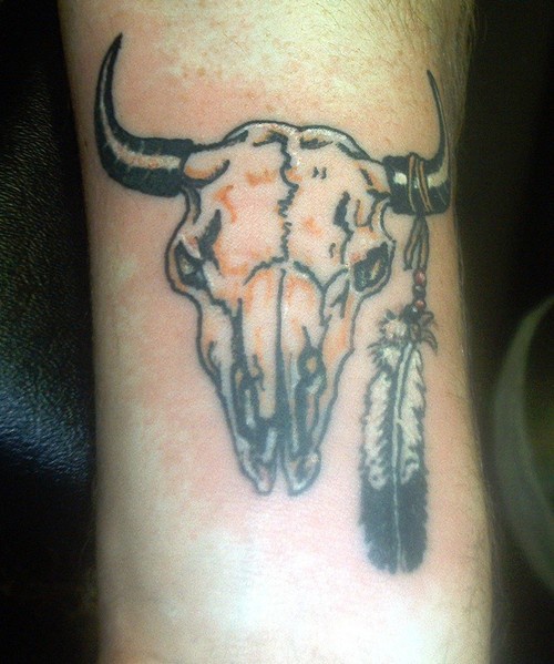Bull skull with one feather tattoo