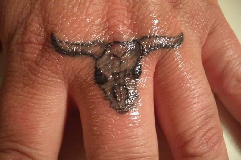 Bull skull tattoo on finger