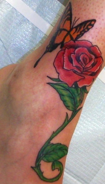 Butterfly on red rose tattoo