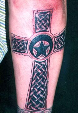 Le tatouage d"étoile dans le croix celtique sur la jambe