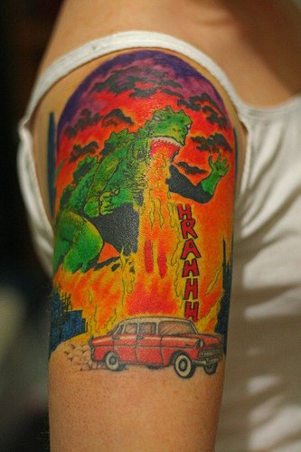 godzilla spruzza fuoco sul auto fumetto tatuaggio colorato
