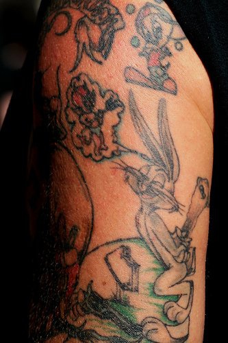 Tatuaggio uccello Tweety e bugs tatuati sul braccio