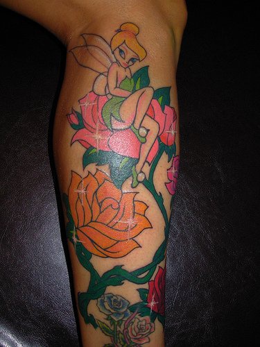 Tatuaje de Tinker bell con rosas en la pierna.