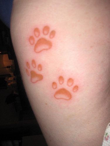 Red cat paw prints tattoo
