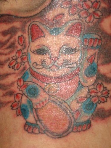 Le tatouage de maneki-neko chat rouge et bleu