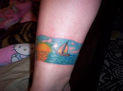 Tatuaje cualitativo de un paisaje con un barco.