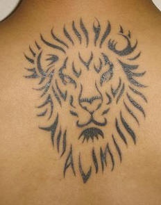 El tatuaje minimalista tribal de la cabeza de un leon en negro hecho en  la espalda