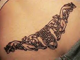 Tatuaje de lobos en estilo celta en el bajo de la espalda