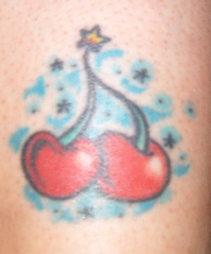 Tatuaje de cerezas con el fondo azul