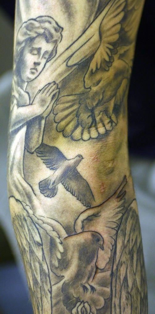 Praying cherub with doves tattoo on sleeve