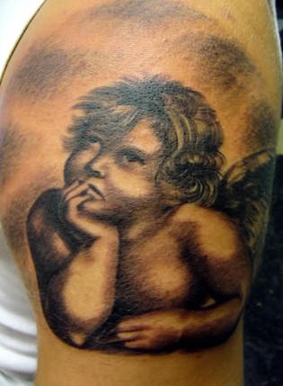 Classic thoughtful cherub tattoo on shoulder