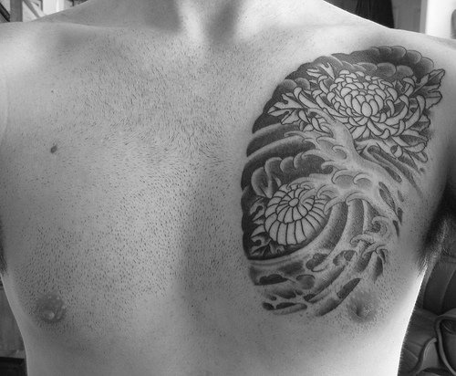 Curled bush chest tattoo