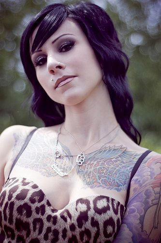Tattoo mit schlangenartigem Ornament auf der Brust