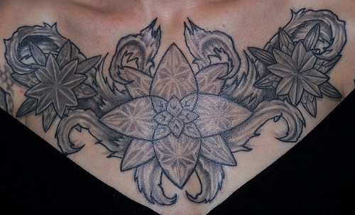 Black figured flowers chest tattoo