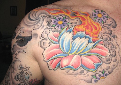 Tatouage sur la poitrine avec une fleure en couleurs de flamme