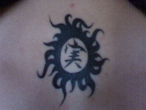 Schwarzes Tattoo mit chinesischer Hieroglyphe in Sonne