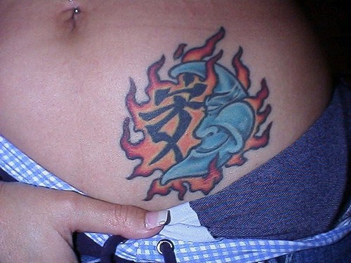 tatuaje de un jerogrífico con medialuna sonriendo en llamas