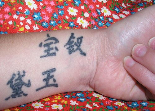 Le tatouage d&quothiéroglyphes chinois sur le poignet