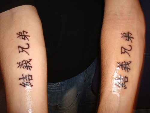 Chinese hieroglyphs tattoo on torch arms
