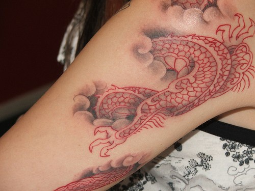 3d drago cinese rosso con testa nascosta su nuvole tatuaggio