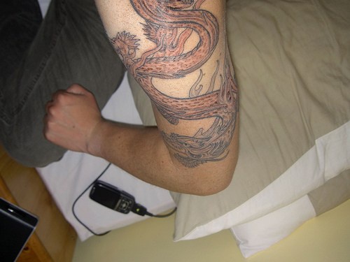 drago cinese largo sul braccio tatuaggio