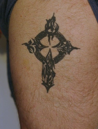 tatuaje en tinta negra de cruz en estilo tribal