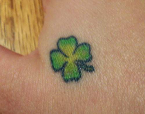 Un petit tatouage de trèfle à quatre feuilles sur la main