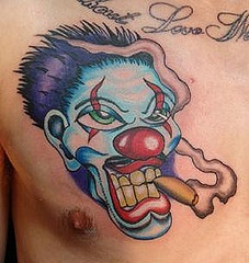 Smoking clown face tattoo on chest