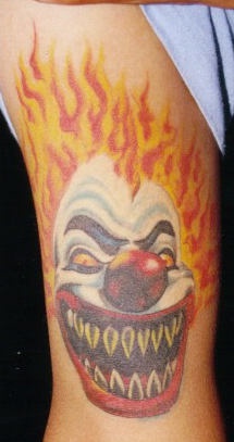 tatuaje de payaso en llamas con dientes afilados