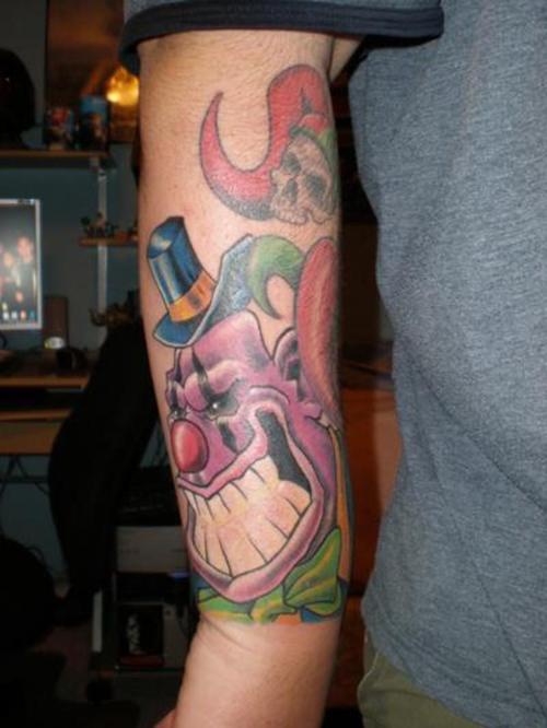 viola pagliaccio con ampio sorriso e teschio tatuaggio sul braccio