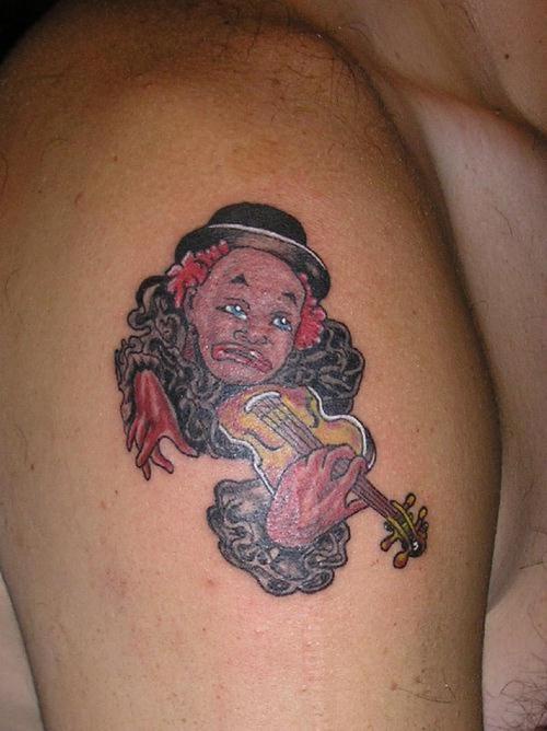 Trauriger Clown spielt Geige Tattoo