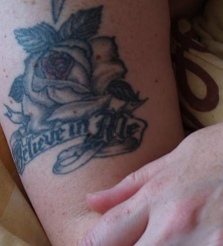 Black rose and writings tattoo